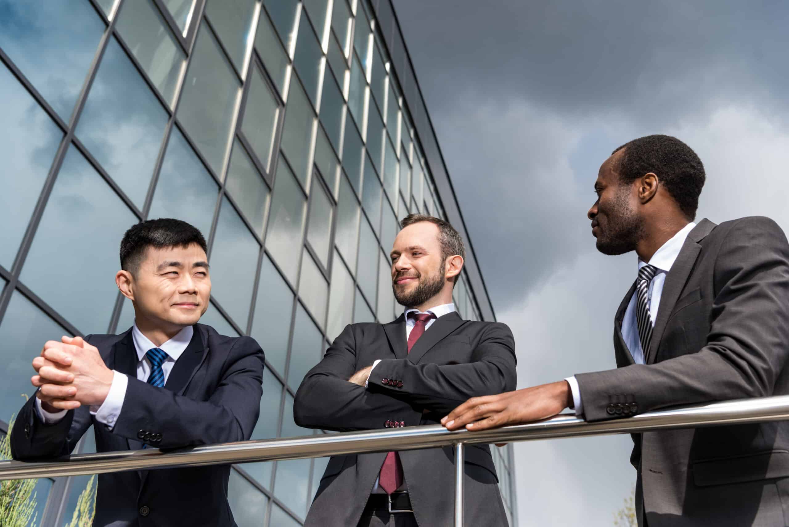 multicultural business team meeting outdoors near office building, successful businessmen concept
