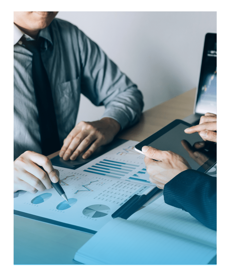 Two professionals analyzing financial performance charts and digital data during an investment strategy meeting